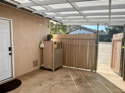 a garage with a refrigerator and a fence at Haven Vibe in Escondido