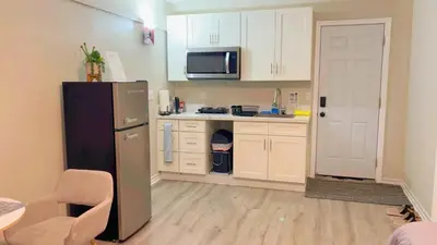 a kitchen with white cabinets and a black refrigerator at Haven Vibe in Escondido