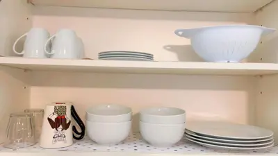 a kitchen shelf with plates and cups and dishes at Haven Vibe in Escondido