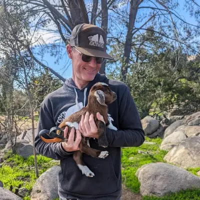 a man holding a baby duck in his hands at A Quiet Fireside Retreat in a Scenic Glamping Dome in Fallbrook