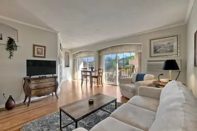 a living room with a couch and a tv and a table at La Costa Condo Pool BBQ Gated Parking in Carlsbad
