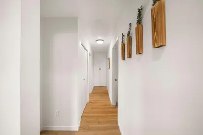 a hallway of a house with white walls and wooden floors at Parkside Paradise in San Diego