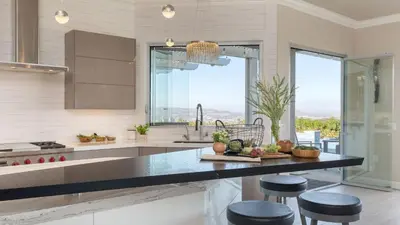 a kitchen with a sink and a counter with stools at Summit Ranch by AvantStay Infinity Pool Views in Temecula