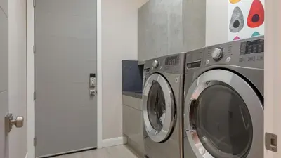 a washing machine in a laundry room with a door at Summit Ranch by AvantStay Infinity Pool Views in Temecula
