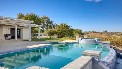 a swimming pool with blue water in a yard at Summit Ranch by AvantStay Infinity Pool Views in Temecula
