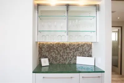 a glass display cabinet with glasses in it at Hi-Tech Hideaway - Modern & Ocean Front! in Solana Beach