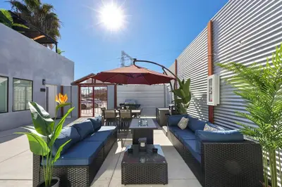 a patio with a blue couch and an umbrella at Harborside Suite 12 with Hot Tub and King Beds in San Diego