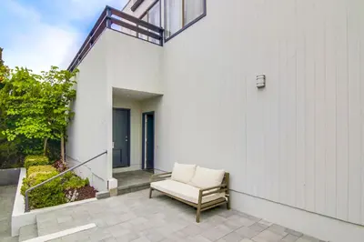a white chair sitting on a patio next to a building at Beryl Bungalow in San Diego