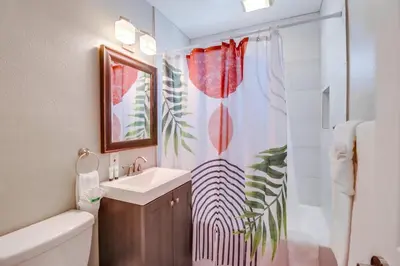 a bathroom with a sink and a shower curtain at Casa Azul Lower in San Diego