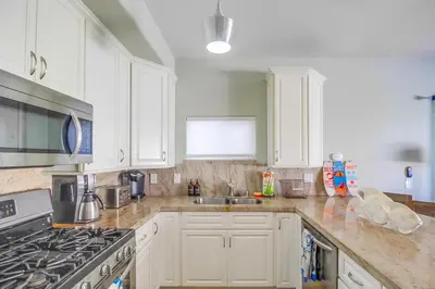 a kitchen with white cabinets and a stove top oven at Coastal Haven in San Diego