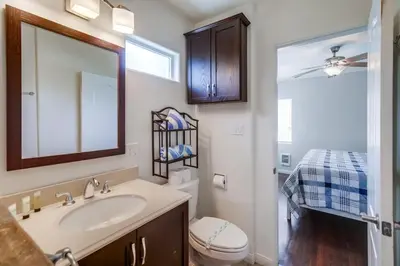a bathroom with a sink and a toilet and a mirror at Manhattan Shores 1B in San Diego