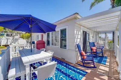 a patio with a table and chairs and an umbrella at Coral Cottage in San Diego