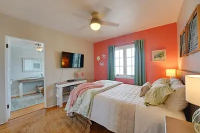 a bedroom with a bed with an orange wall at Coral Cottage in San Diego