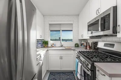 a kitchen with white cabinets and a refrigerator at Bayfront 1-BR with Stunning View Steps to the Sand in San Diego
