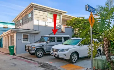 a truck and a car parked in front of a house at Bayfront 1-BR with Stunning View Steps to the Sand in San Diego