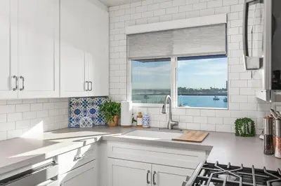 a white kitchen with a sink and a window at Bayfront 1-BR with Stunning View Steps to the Sand in San Diego