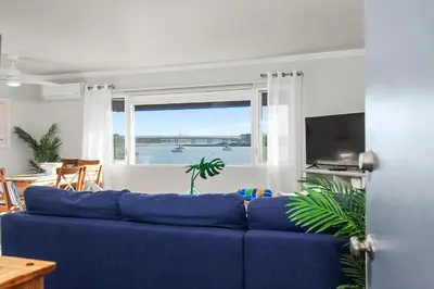 a blue couch in a living room with a window at Bayfront 1-BR with Stunning View Steps to the Sand in San Diego
