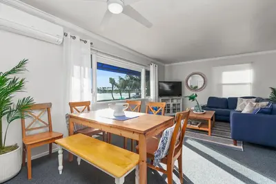 a living room with a table and a blue couch at Bayfront 1-BR with Stunning View Steps to the Sand in San Diego