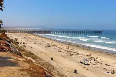 a group of people on a beach with a pier at 500 ft to Ocean Relaxing stay Parking WiFi 838 in San Diego