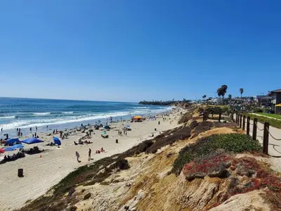 a group of people on a beach near the ocean at 500 ft to Ocean Relaxing stay Parking WiFi 840 in San Diego