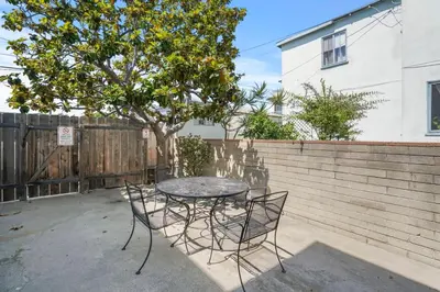 a table and chairs in a backyard with a tree at 500 ft to Ocean Relaxing stay Parking WiFi 836 in San Diego