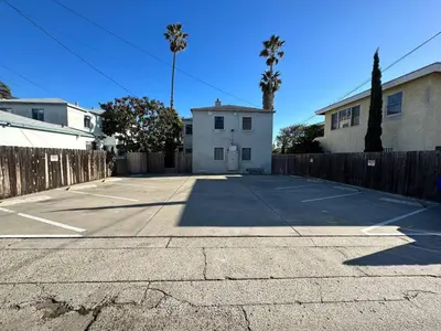 a parking lot with a house and a fence at 500 ft to Ocean Relaxing stay Parking WiFi 836 in San Diego