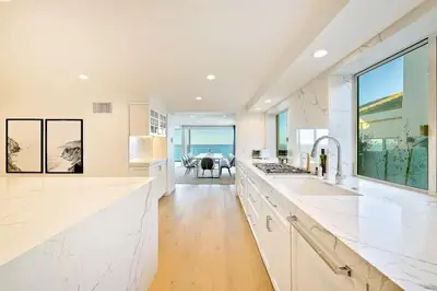 a kitchen with white countertops and a view of the ocean at Cliffside Haven Where Ocean Meets Sky in San Diego