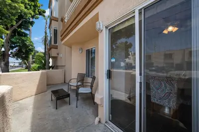 a patio with a glass door with a chair and a table at Townhouse 1 Block From Bay With Yard & Parking in San Diego