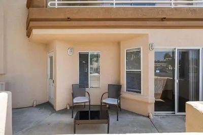 a patio with two chairs and a table and windows at Townhouse 1 Block From Bay With Yard & Parking in San Diego
