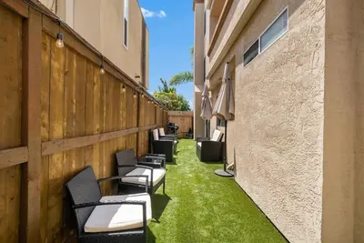 a row of chairs on the side of a building with green grass at Townhouse 1 Block From Bay With Yard & Parking in San Diego