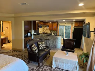 a living room with two chairs and a kitchen at Guesthouse in Coastal Del Mar, California in San Diego