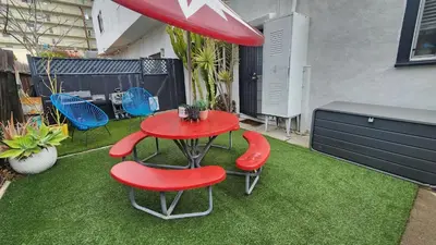 a red table and two red chairs on a lawn at Urban Beach Getaway 2 in San Diego