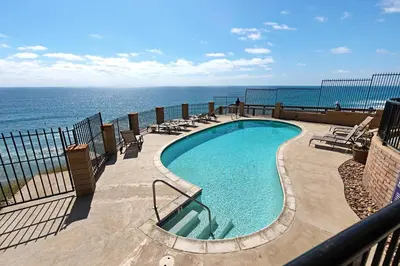 a swimming pool with the ocean in the background at Breathtaking Bungalow - DMST22 in Solana Beach