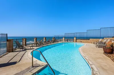 a swimming pool with chairs and the ocean in the background at Breathtaking Bungalow - DMST22 in Solana Beach