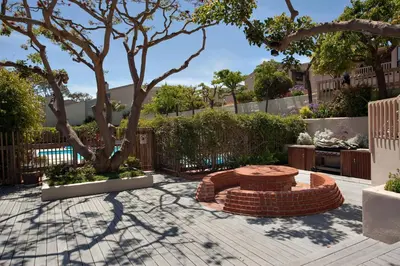 a patio with a brick bench and a tree at Above the Waves - SUR116 in Solana Beach
