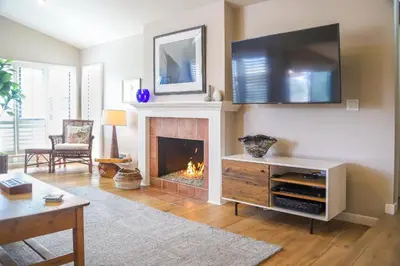 a living room with a fireplace and a flat screen tv at High Tides & Good Vibes SUR169 in Solana Beach