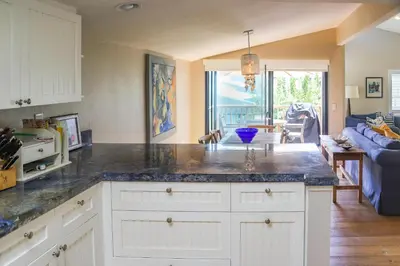 a kitchen with a counter top and a living room at High Tides & Good Vibes SUR169 in Solana Beach