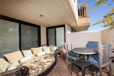 a porch with a couch and a table and chairs at High Tides & Good Vibes SUR169 in Solana Beach