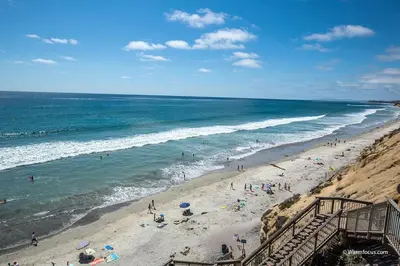 a group of people on a beach near the ocean at High Tides & Good Vibes SUR169 in Solana Beach