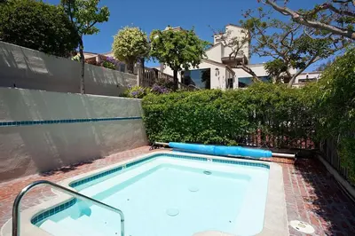 a swimming pool in front of a fence at Sun, Sand, & Vitamin Sea - SUR5 in Solana Beach