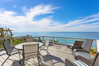 a deck with chairs and a table and the ocean at Coastal Soul - ENC656N in Encinitas