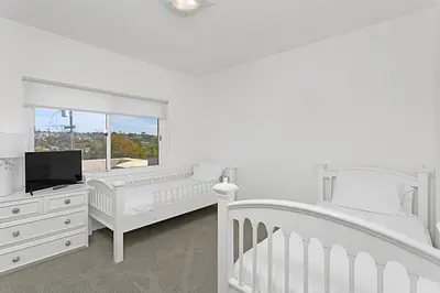 a white bedroom with two beds and a tv at Coastal Soul - ENC656N in Encinitas
