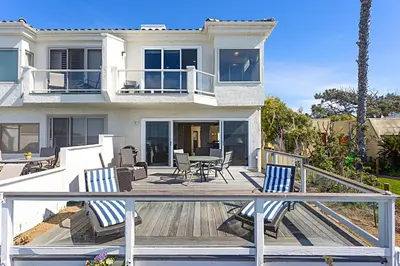 a house with a deck with chairs and a table at Coastal Soul - ENC656N in Encinitas