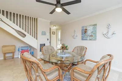 a dining room with a glass table and chairs at Sea'Esta by the Shore-DMBC852S in Solana Beach