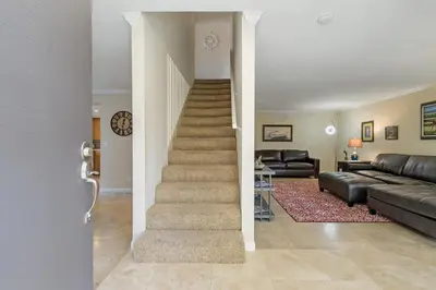 a living room with a staircase with a couch and a stair case at Sea'Esta by the Shore-DMBC852S in Solana Beach
