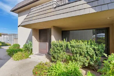a house with a window and bushes in front of it at Sea'Esta by the Shore-DMBC852S in Solana Beach