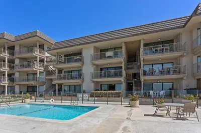 an apartment building with a swimming pool and patio at Slow M'ocean - DMBC853A in Solana Beach
