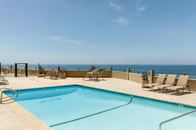 a swimming pool with the ocean in the background at Slow M'ocean - DMBC853A in Solana Beach