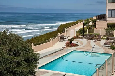 a swimming pool with the ocean in the background at Slow M'ocean - DMBC853A in Solana Beach