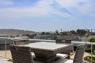 a patio with a table and chairs on a balcony at Vista Pacific - DM1050 in Del Mar